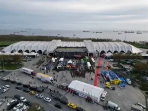 Entrance area of the logitrans 2025 venue at Dr. Mimar Kadir Topbaş Show and Art Center, with high visitor attendance and cargo ships visible offshore.